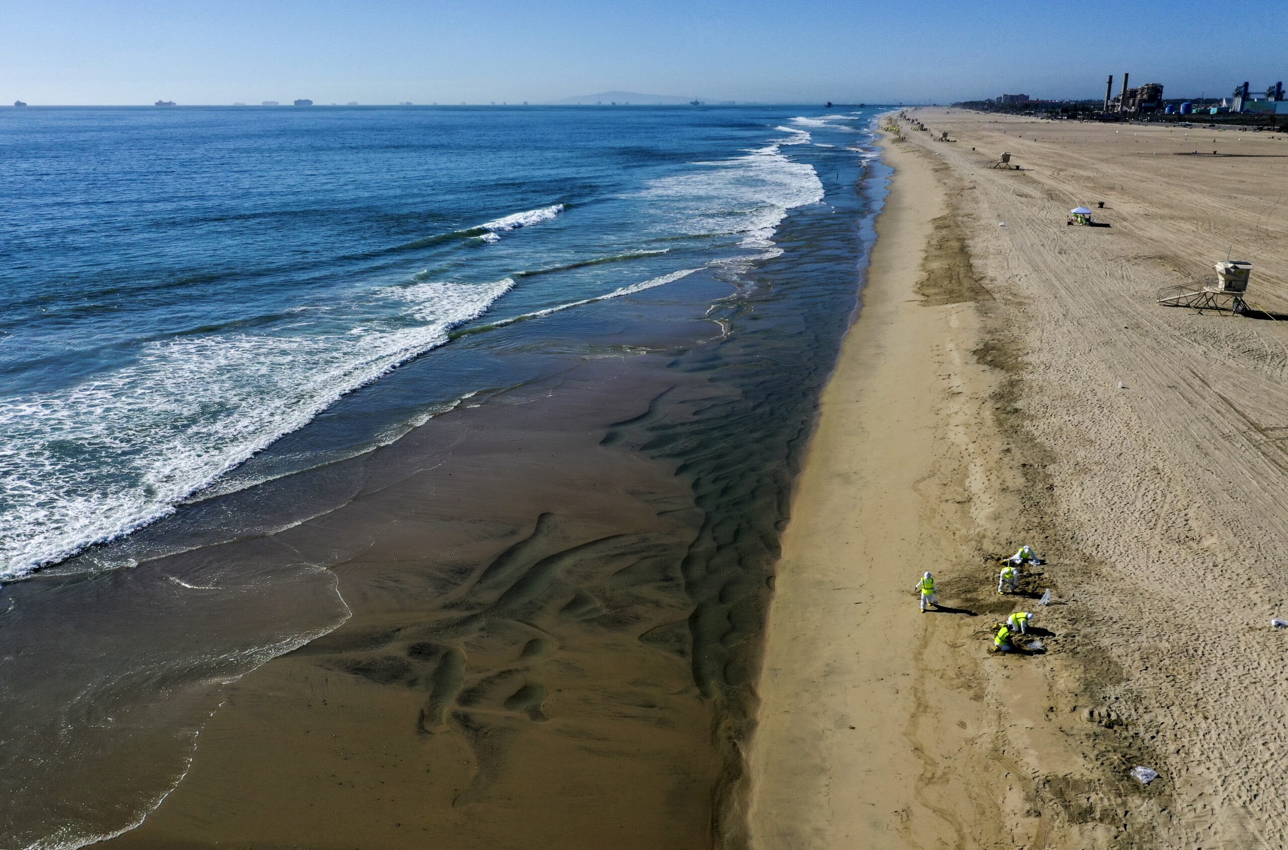 An aerial view of oil spill cleanup crew members from New Jersey cleaning up the oil spill at Huntington State Beach.