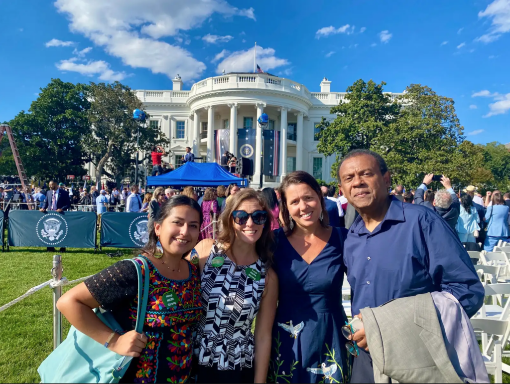 Group posing for a photo in front of The White House during the announcement of The Inflation Reduction Act.