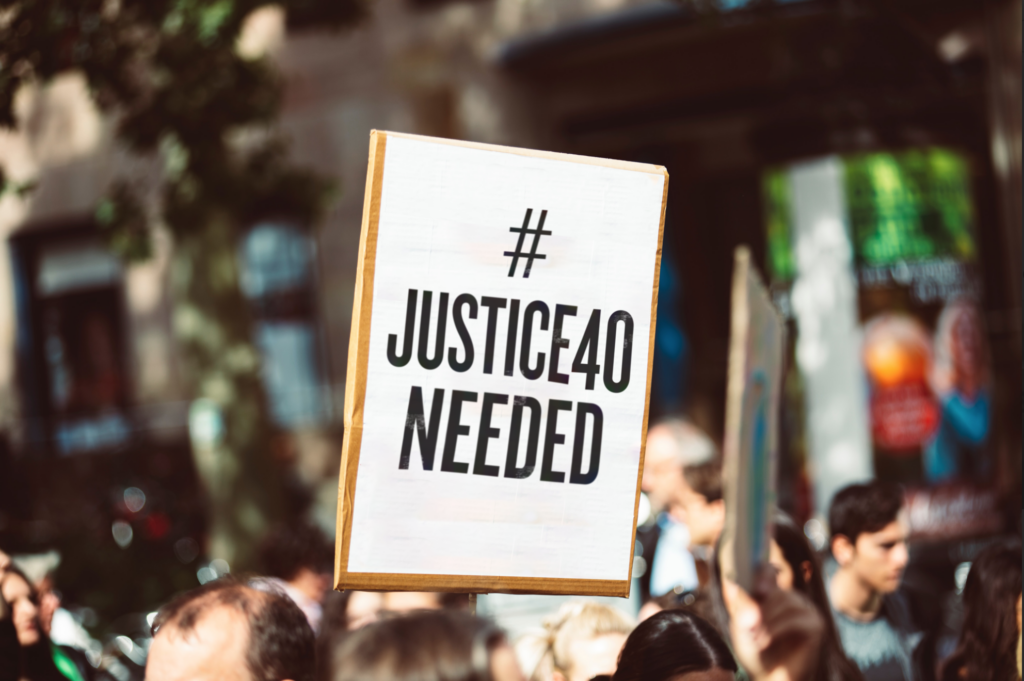 A sign reading #Justice40 Needed